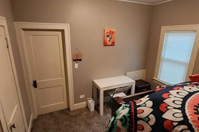 a bedroom with a bed and a table and a door at Comfy 3brd in Cleveland in Cleveland Heights