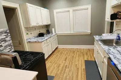 a kitchen with white cabinets and a black stove at Comfy 3brd in Cleveland in Cleveland Heights