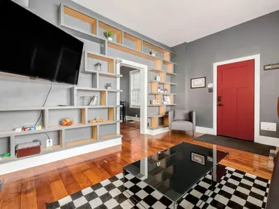 a living room with a tv and a red door at Pet-Friendly German Village Haus Wifi Walkable in Columbus