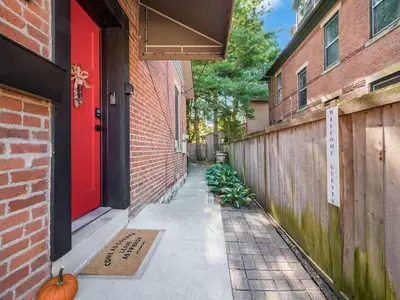 a red door on a brick building with a pumpkin on the sidewalk at Pet-Friendly German Village Haus Wifi Walkable in Columbus