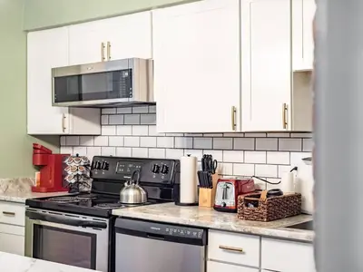 a kitchen with white cabinets and a stove top oven at Blenkner Bungalowgvillagepetsok in Columbus