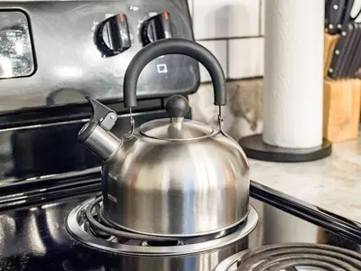 a metal tea kettle sitting on a stove at Blenkner Bungalowgvillagepetsok in Columbus