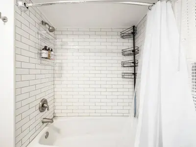 a white bathroom with a tub and a shower curtain at Blenkner Bungalowgvillagepetsok in Columbus