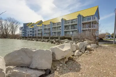 a large building with rocks in front of it at Waterfront Middle Bass Condo with Lake Erie Views! in Middle Bass