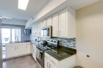 a kitchen with white cabinets and a stove top oven at Waterfront Middle Bass Condo with Lake Erie Views! in Middle Bass