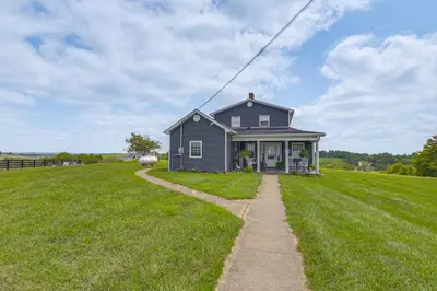 a small house on a grassy hill with a pathway at Quiet Kentucky Vacation Rental with Hot Tub in Berry