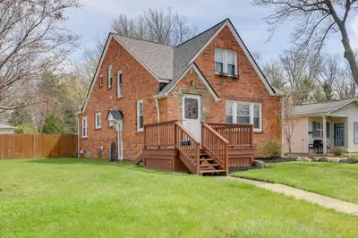 a brick house with a porch and a deck at Walk to Lake Erie Chic Home, Private Yard and Deck in Avon Lake