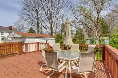 a patio with a table and an umbrella on a deck at Walk to Lake Erie Chic Home, Private Yard and Deck in Avon Lake