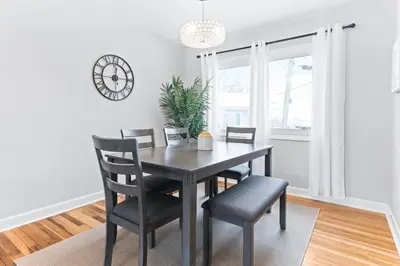 a dining room with a table and chairs and a clock at The Cranbrook- Close to OSU-Downtown Columbus-Short North-Clintonville-Upper Arlington in Columbus