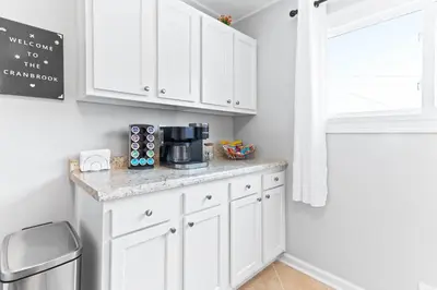 a kitchen counter with white cabinets and a window at The Cranbrook- Close to OSU-Downtown Columbus-Short North-Clintonville-Upper Arlington in Columbus