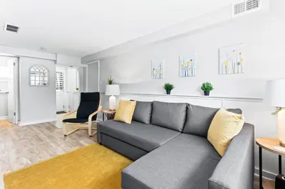 a living room with a gray couch and yellow pillows at The Cranbrook- Close to OSU-Downtown Columbus-Short North-Clintonville-Upper Arlington in Columbus