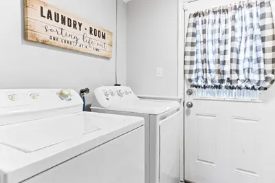 a white laundry room with a washer and dryer at The Cranbrook- Close to OSU-Downtown Columbus-Short North-Clintonville-Upper Arlington in Columbus