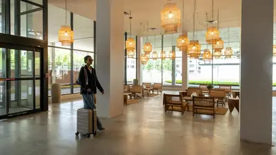 a man walking through a building with a suitcase at Dayton Vitality Hotel - Downtown in Dayton