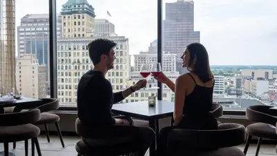 a man and woman sitting at a table with a glass of wine at Dayton Vitality Hotel - Downtown in Dayton