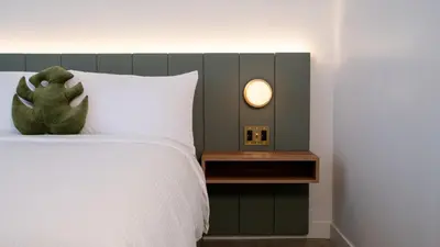 a bedroom with a white bed with a green headboard at Dayton Vitality Hotel - Downtown in Dayton