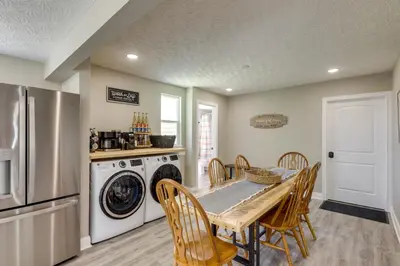 a kitchen with a table and a washer and dryer at Williamstown Vacation Rental Private Deck and Yard in Williamstown