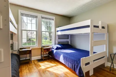 a bedroom with a bunk bed and two windows at Williamstown Vacation Rental Private Deck and Yard in Williamstown