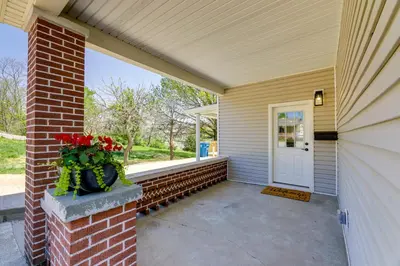 a front porch of a house with a door and flowers at Williamstown Vacation Rental Private Deck and Yard in Williamstown
