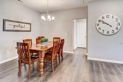 a dining room with a table and chairs and a clock at Spacious Home with Patio Near Fishers! in Fishers