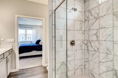 a bathroom with a shower and a bed in a room at Spacious Home with Patio Near Fishers! in Fishers