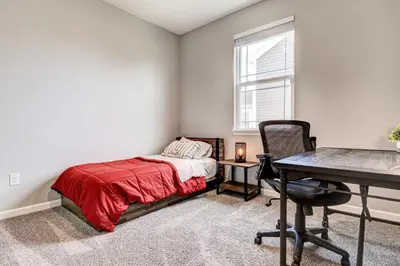 a bedroom with a bed and a desk and a window at Spacious Home with Patio Near Fishers! in Fishers