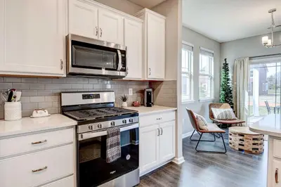 a kitchen with a stove and a microwave at Spacious Home with Patio Near Fishers! in Fishers