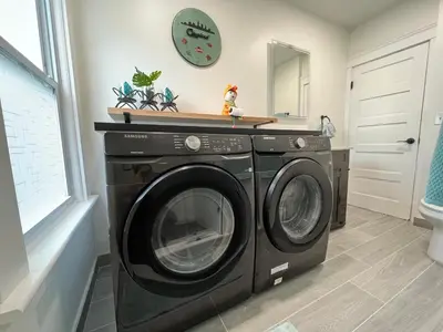 a washing machine in a laundry room with a mirror at Trendy in Tremont, Cleveland (Upper) in Cleveland