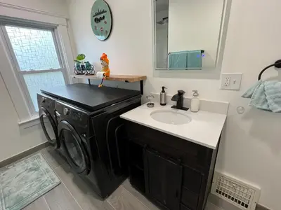 a bathroom with a washing machine and a sink at Trendy in Tremont, Cleveland (Upper) in Cleveland