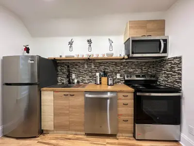 a kitchen with a stainless steel refrigerator and microwave at Trendy in Tremont, Cleveland (Upper) in Cleveland